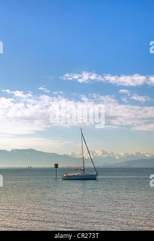 a lone sailing boat in the morning on a calm lake Stock Photo