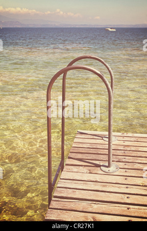 Ladder into a lake from a wooden pier Stock Photo