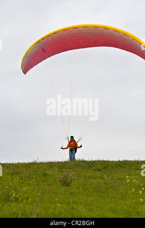 Paraglider kites a canopy in the wind prior to launching Stock Photo