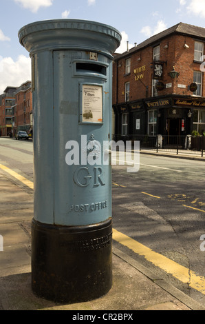 Post box Liverpool Road Manchester in an unusual light blue grey colour (for air mail) with White Lion pub in the background Stock Photo
