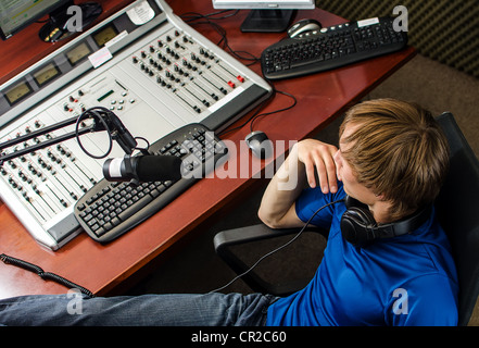 Dj working in front of a microphone on the radio, from the top Stock Photo