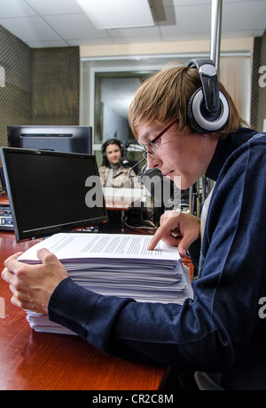Funny anchorman in front of a microphone on the radio Stock Photo