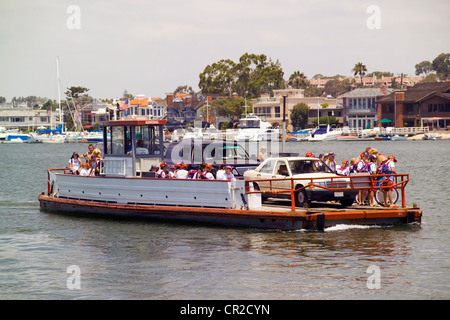 Historic three-car ferryboats cross Newport Harbor between the Fun Zone on the Balboa Peninsula and Balboa Island in Newport Beach, California, USA. Stock Photo