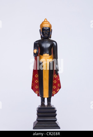 Khmer standing Buddha lacquer statue dispelling fear on a white background - Siem Reap Province, Cambodia Stock Photo