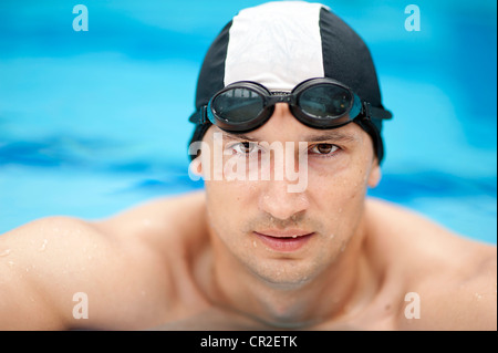 Professional male swimmer wearing a hat and goggles Stock Photo