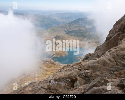 Llyn Llydaw appears through the cloud on an ascent of Crib Goch, the first peak of the classic Snowdon Horseshoe route Stock Photo