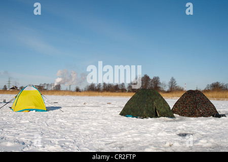 Winter fishermen tents on frozen river Stock Photo