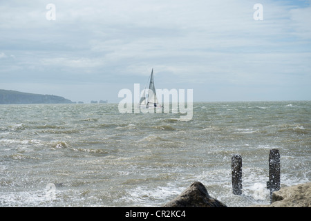 Yacht in rough seas passing Hurst Castle and the Needles, Isle of Wight Stock Photo