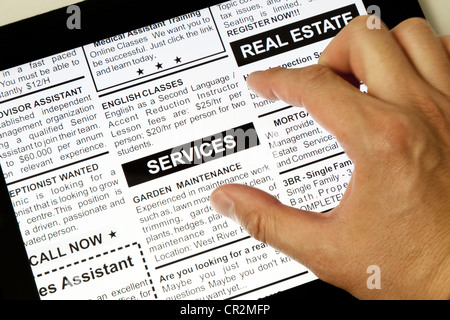 Fake Classified Ad, newspaper and Touch Screen, business concept. Stock Photo