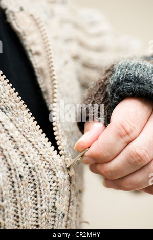 Abstract close up of man zipping up a hand-knitted jumper Stock Photo
