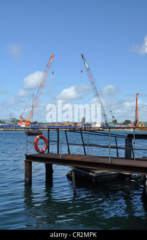 Part of Poole Harbour, Dorset, with cranes in use during the construction of the Twin Sails lifting bridge in the background. Stock Photo