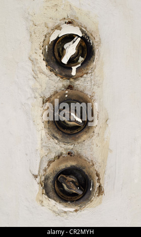 three vintage light switches in a row Stock Photo