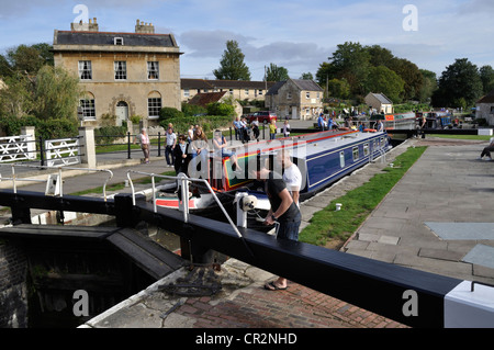 Two narrowboats negotiate Bradford on Avon lock on the Kennet and Avon Canal as one of the crew members opens the sluice Stock Photo