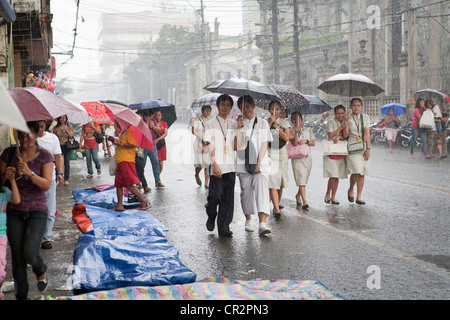 College students walking during a heavy downpour. Cebu City, Cebu, Visayas, Philippines. Stock Photo