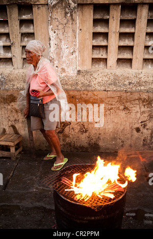 Woman selling prayer candles outside Basilica of the Santo Nino church. Cebu City, Cebu, Visayas, Philippines. Stock Photo