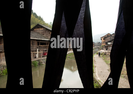 Indigo dyed clothes hanging to dry in a Wind and Rain' bridge, Zhaoxing Dong Village, Southern China Stock Photo