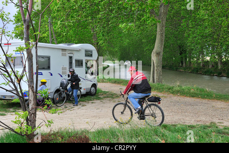 Tourists in motorhome parked on the banks of the Canal du Midi  for a cycle ride along towpath near Hommes,South of France Stock Photo