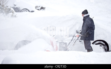 Man with Snowblower during snow storm Stock Photo