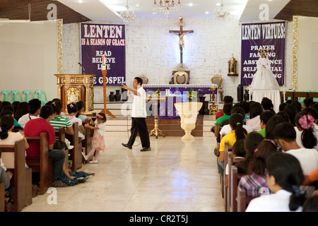 Lapu-Lapu City, Philippines, 26/02/2012: 200-300 babies being baptised in a single 3 hour ceremony at Mactan Air Base Chapel. Stock Photo