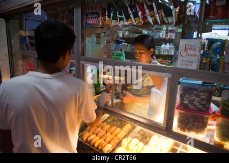 Man shopping at a sari-sari store and bakeshop. Lapu-Lapu City, Metro Cebu, Mactan Island, Visayas, Philippines. Stock Photo