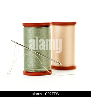 Two spools of thread with needle for sewing isolated on white background Stock Photo