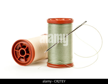 Two spools of thread with needle for sewing isolated on white background Stock Photo
