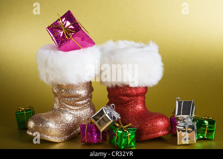 Santa boots and gifts on gold background Stock Photo