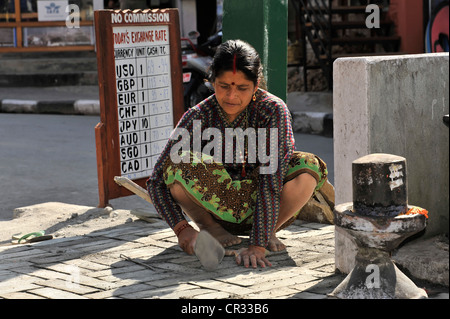 Nepalese woman repairing road damage, Pokhara, Nepal, Asia Stock Photo