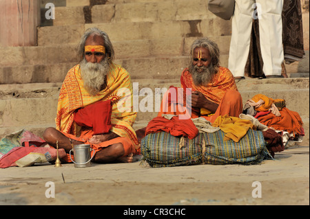 Sadhus on a ghat or steps on the banks of the Ganges in Varanasi, Benares, Uttar Pradesh, India, South Asia Stock Photo