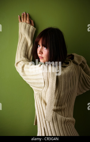 Beautiful brunette in a jacket isolated on a green background Stock Photo