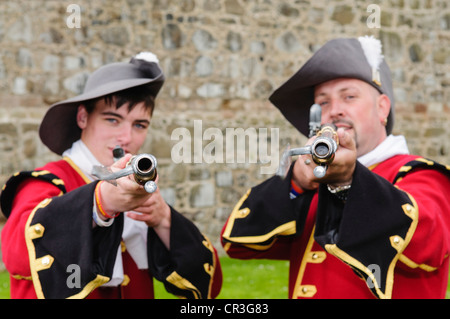 Two redcoats pointing 17th century rifles Stock Photo