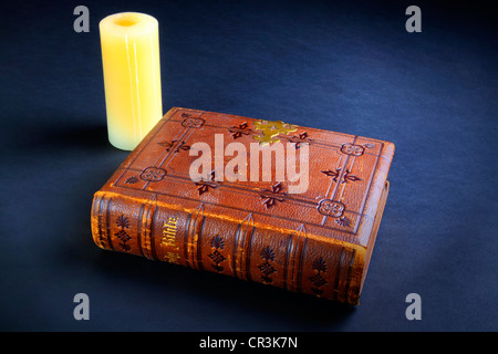 Leather bound Christian bible with candle Stock Photo