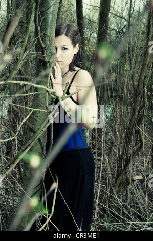 Woman hiding behind a tree, Gothic Stock Photo