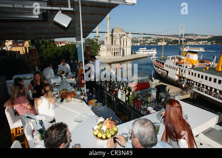 Turkey, Istanbul, bar on Bosphorus banks, Ortakoy Mosque and Bosphorus Bridge in the background Stock Photo