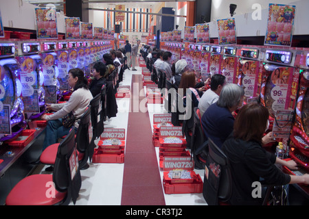 Japanese people playing pachinko in a pachinko parlour. Stock Photo