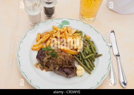 Sirloin steak with onions, green beans, french fries Stock Photo