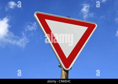 Traffic sign, give way, against a blue sky with clouds Stock Photo