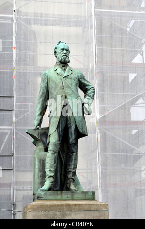 Industrialist and inventor Alfred Krupp with an anvil, monument in front of the covered Marktkirche Church in Essen Stock Photo