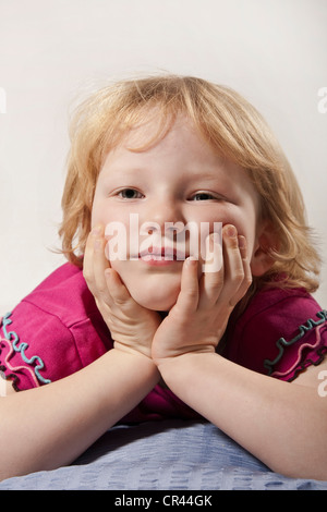 Girl, 5, supporting her chin in her hands Stock Photo