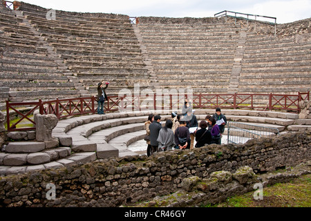 Ruin of Pompeii's small Greek theater or Odeon with students studying site Stock Photo