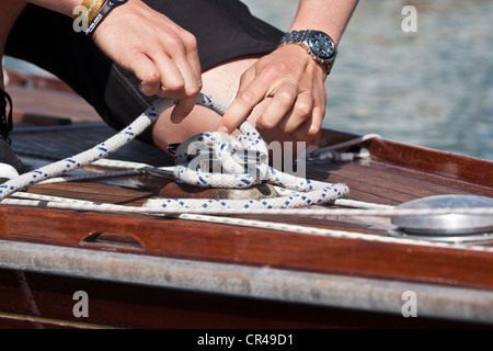 Man tying up a rope on the deck of a yacht Stock Photo