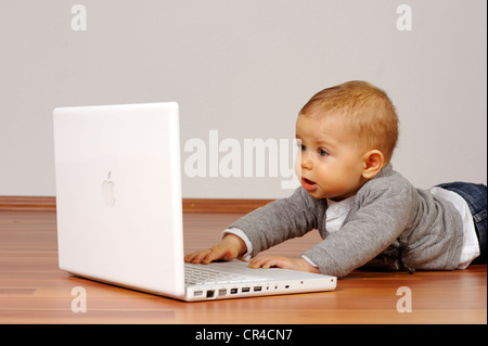 6-month-old infant with laptop Stock Photo