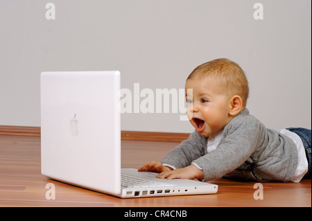 6-month-old infant with a laptop Stock Photo