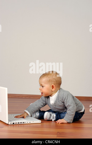 6-month-old infant with a laptop Stock Photo
