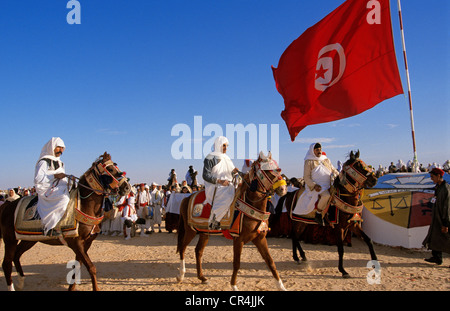 Tunisia, Kebili Governorate, Douz, Desert Festival, riders with the Tunisian flag Stock Photo