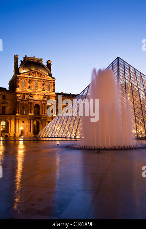 France, Paris, Louvre Museum and Pyramid by the architect Ieoh Ming Pei in the Cour Napoleon, lighting by Claude Engle Stock Photo