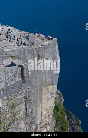 Tourists standing on Pulpit Rock, also known as Preikestolen, Jorpeland, Rogaland, Norway, Scandinavia, Northern Europe Stock Photo