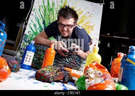 Ian Cook of Pop Bang Colour pictured at his studio in Gaydon.  Ian creates paintings with remote control cars Stock Photo