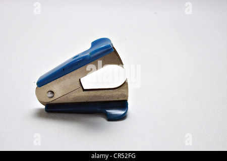 A blue staple remover sits on a white background. Stock Photo