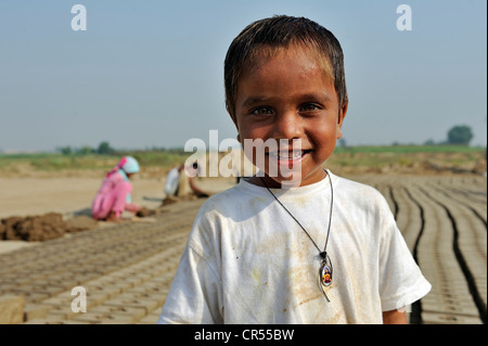 Smiling boy in a brick factory, most of the workers belong to the Christian minority in Pakistan and are particularly affected Stock Photo